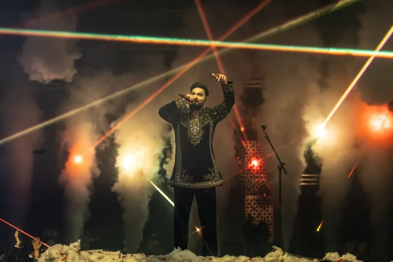 Performer on a stage lit with lasers and smoke